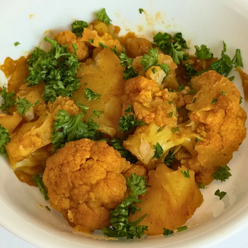 cauliflower chickpeas potato saute in a white ceramic bowel