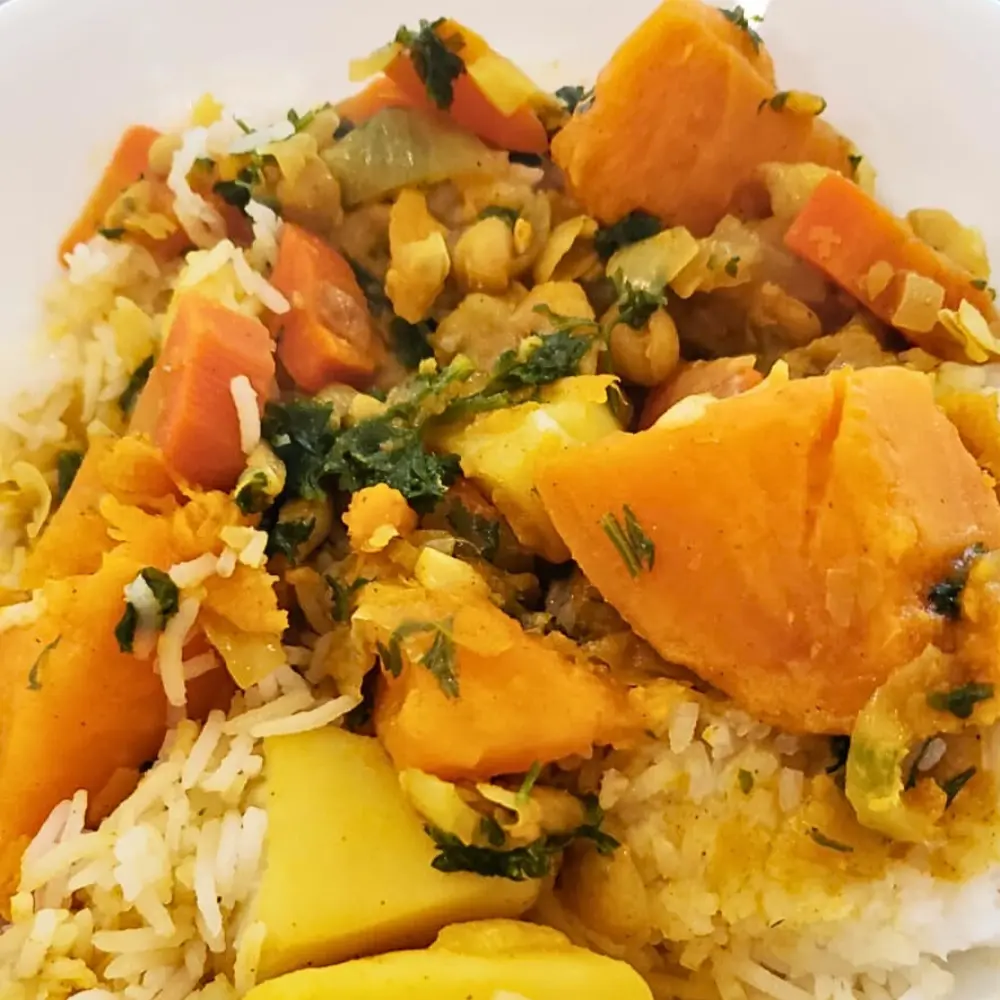 Close-up of hearty vegetable chickpea soup over a bed of rice