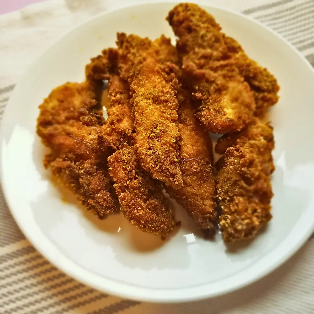 A plate of golden-brown and crispy Baharat Schnitzel Tenders.