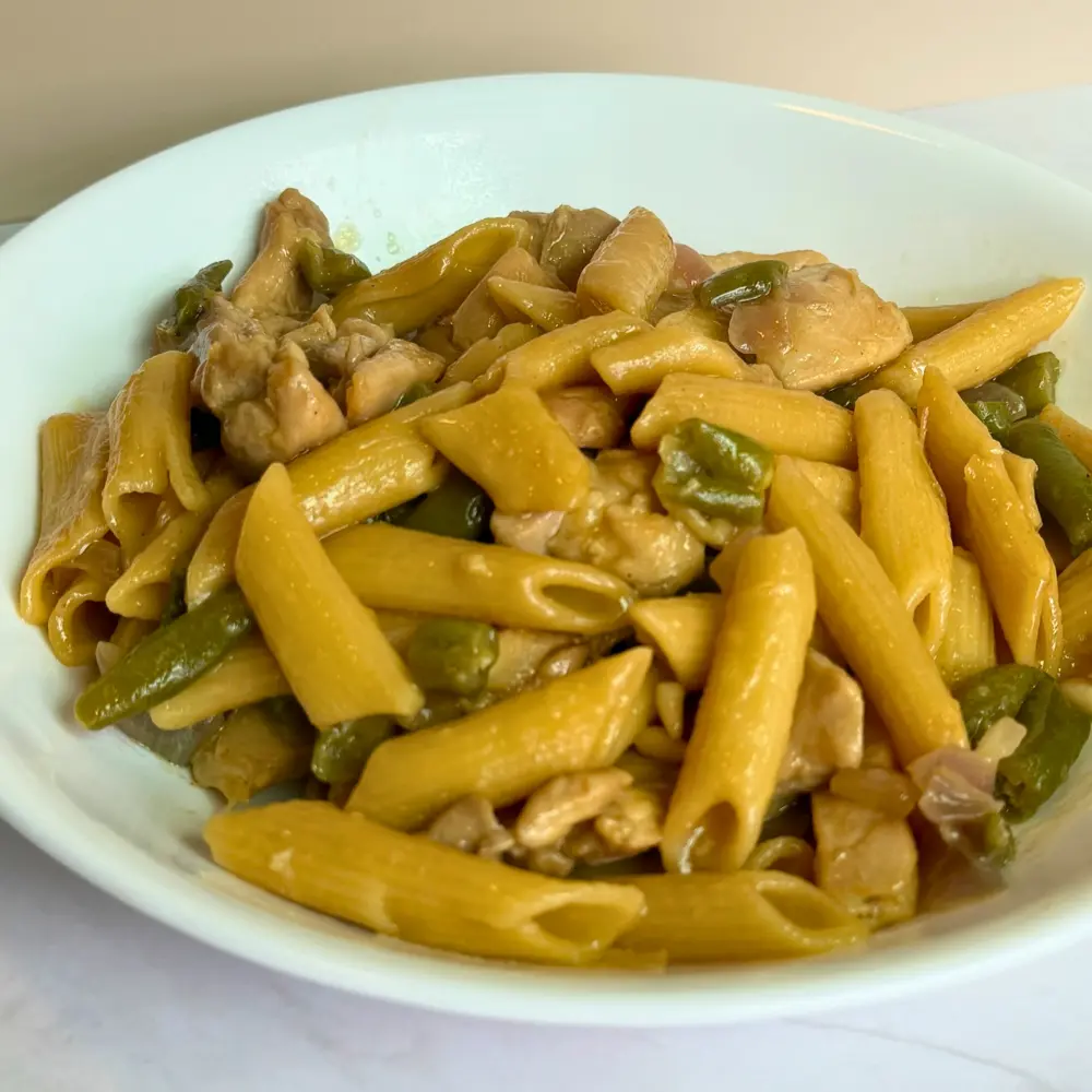 A close up of Date Syrup Mustard Chicken Pasta with green beans